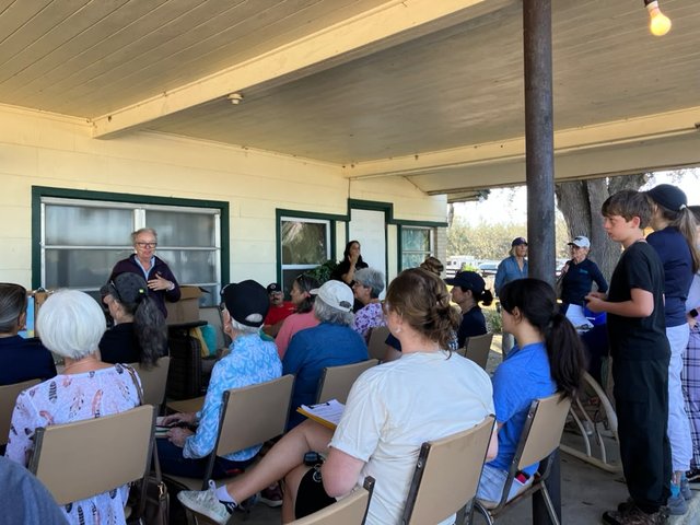 Group of volunteers gathered on a porch for a pre-event briefing